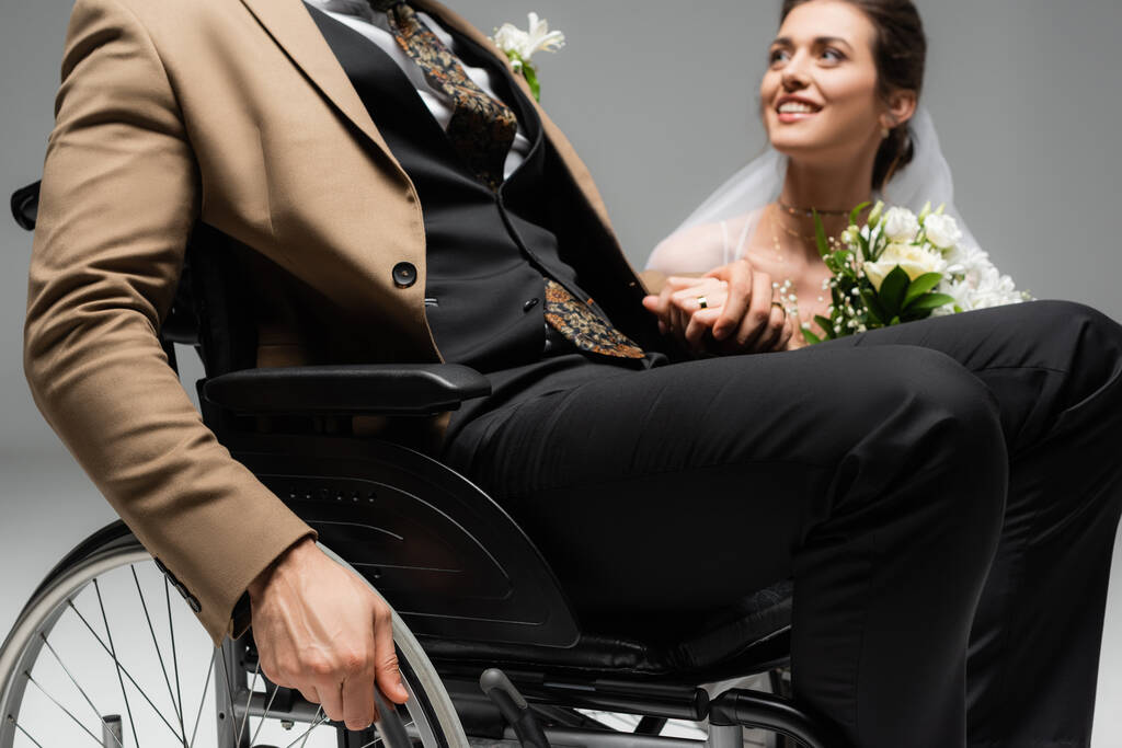 Groom in wheelchair near smiling bride